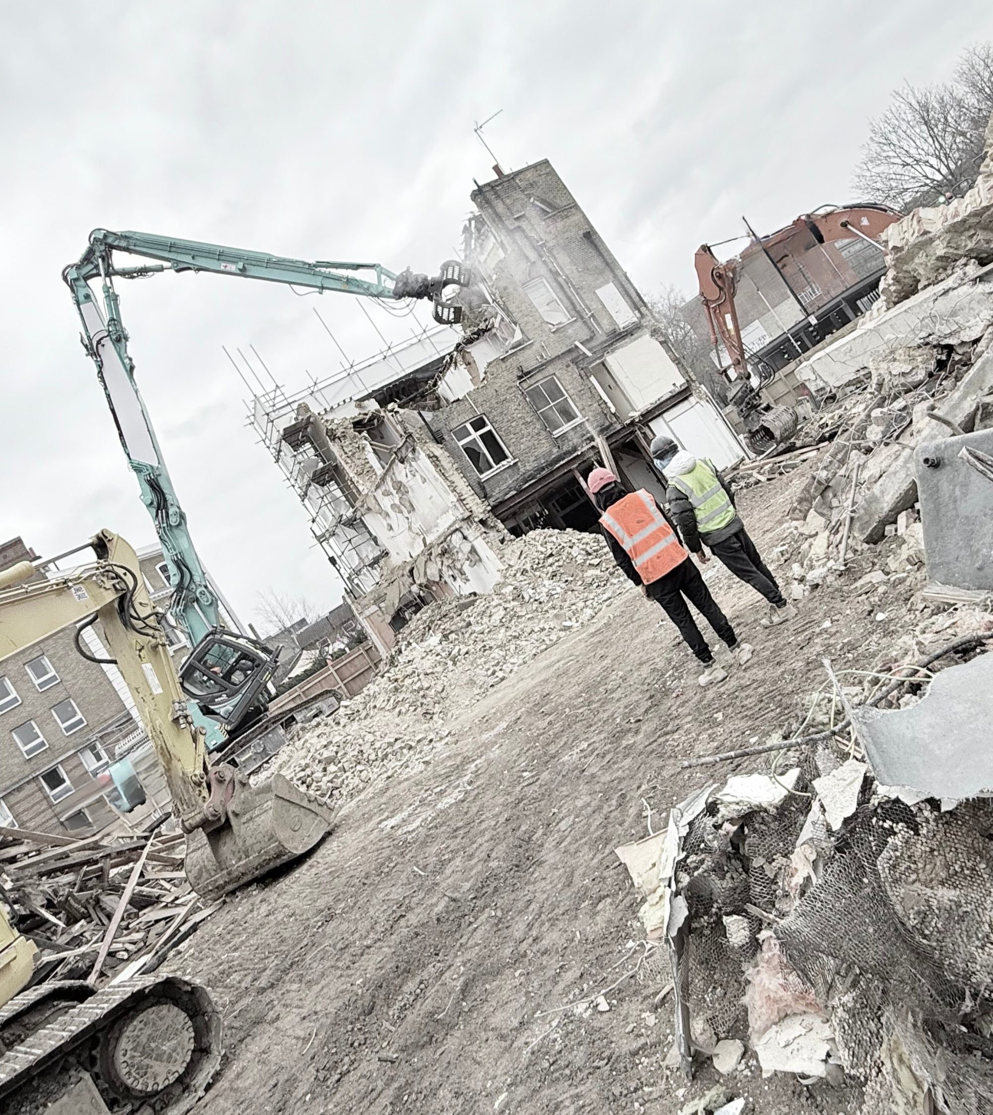 A high-reach excavator taking down a concrete frame